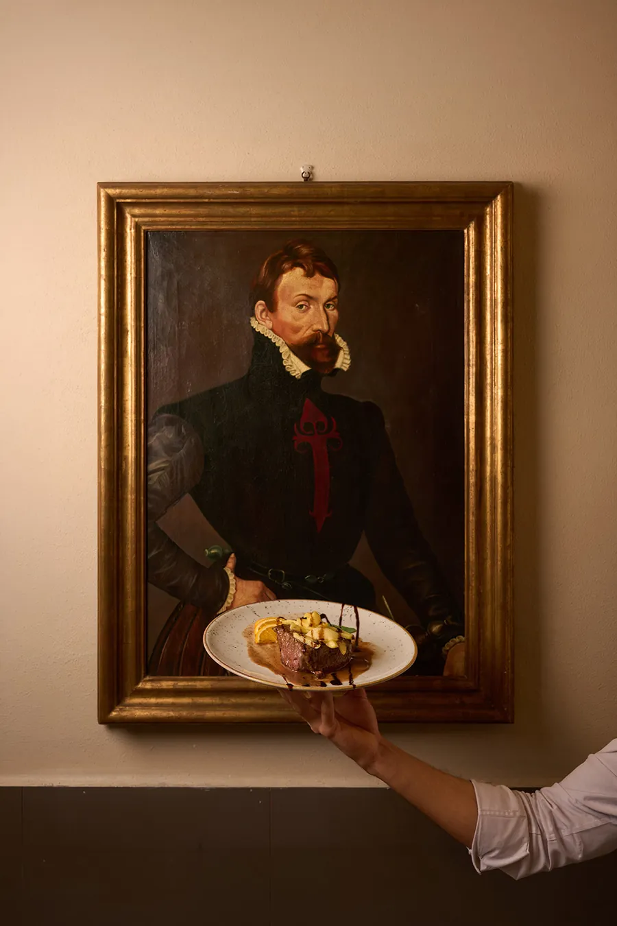 Piatto di carne servito davanti a un quadro all'Osteria dei Medici