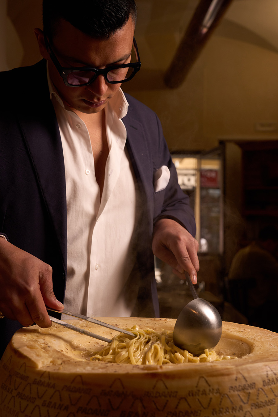 Lo chef manteca i tagliolini nella forma di Parmigiano