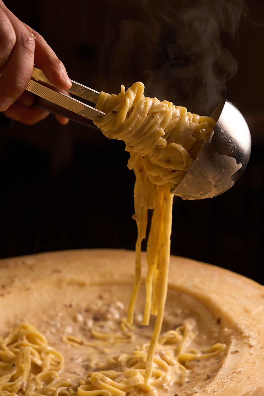 Tagliolini sollevati dalla forma di Parmigiano, con il vapore